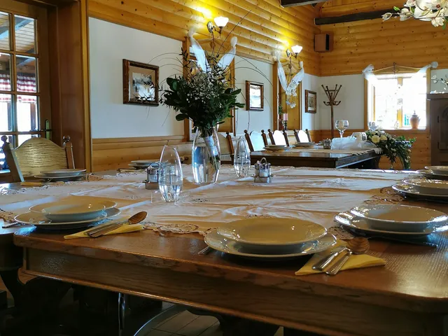 Unutrašnjost restorana s drvenim gredama i postavljenim stolovima
